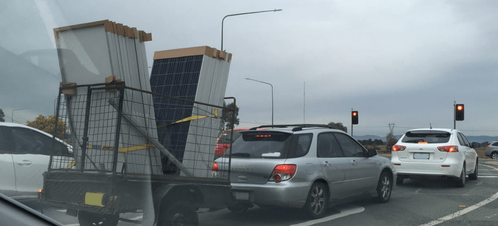 unsecured solar panels in trailer at set of traffic lights